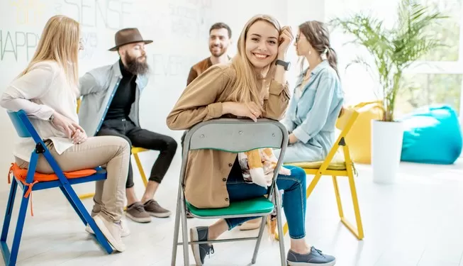 Gruppe junger Erwachsener in lockerer Sitzrunde bei einem Training – Symbolbild für ADHS-Sensibilisierung, Teamstärkung und moderne Unternehmenskultur.